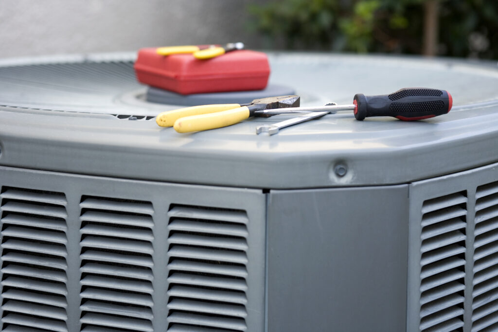 New air conditioner unit getting serviced. Closeup of tools sitting on AC unit.